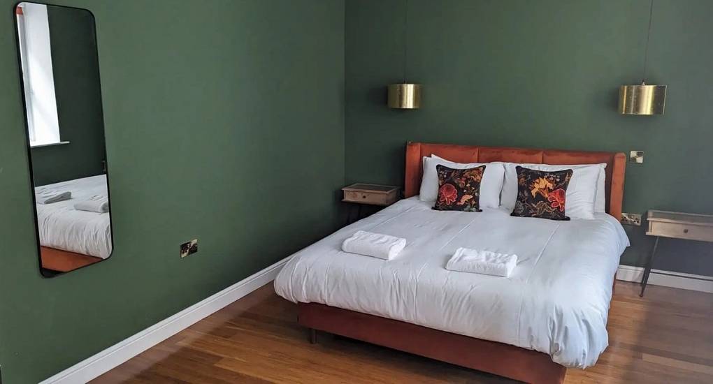 Bright bedroom at Extravagance Edinburgh featuring a double bed and large windows, providing luxury Edinburgh hen weekend accommodation in the heart of Leith.