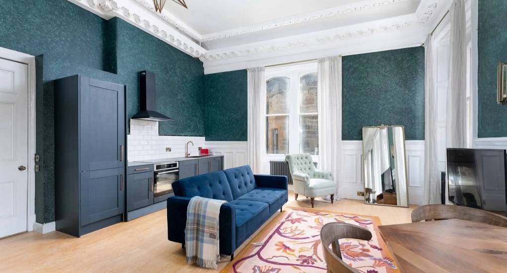 Second spacious lounge area at Extravagance Edinburgh with large windows and group seating, perfect for an Edinburgh hen weekend or stag do apartment stay in Leith.