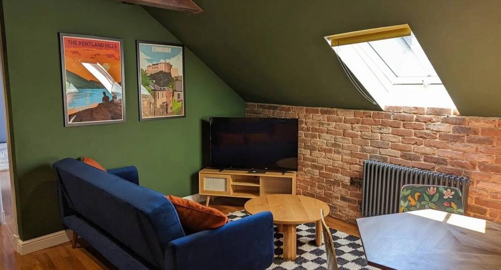 Relaxed loft chill-out lounge in Apartment 9 at Extravagance Edinburgh, featuring stylish seating and city views, ideal for a luxury Edinburgh hen party or large group stag stay in Leith.
