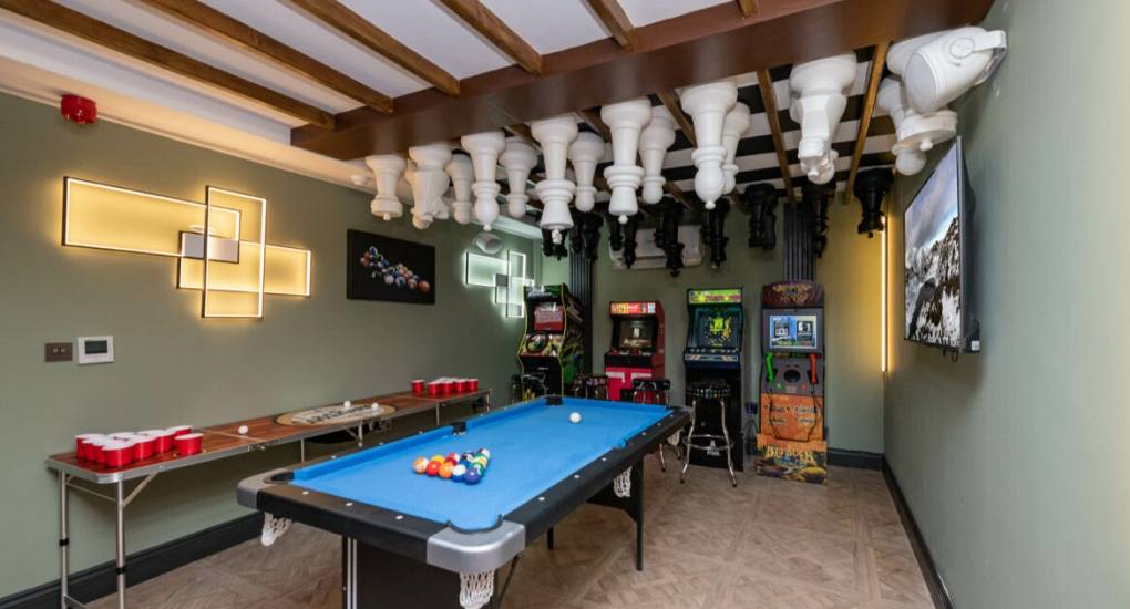 Games room with chessboard and chess set on the ceiling, pool table and arcade machines
