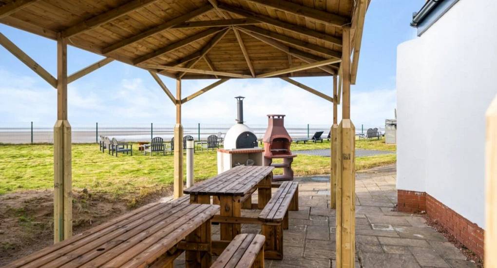 View from garden furniture out at the grounds with firepit, bbq and pizza oven