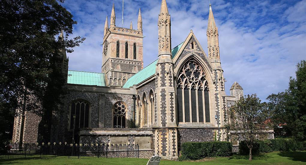 Historic Great Yarmouth Minster surrounded by green lawns and trees, scenic landmark backdrop for a Great Yarmouth hen do.