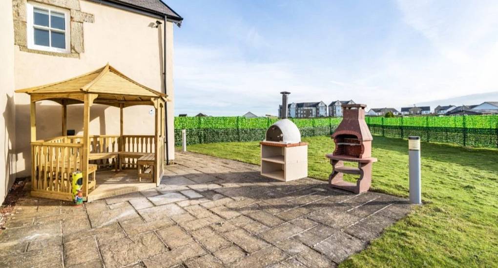 Garden Area with loungers, seating and pergola with the Irish sea in the background