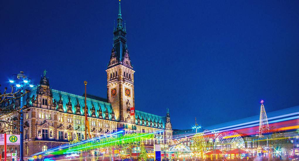 Illuminated Hamburg Rathaus city hall and festive lights on Rathausmarkt at night, vibrant setting for a Hamburg hen do.