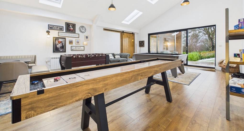 Games room with shuffleboard, foosball and pool table at Grand Hookstone, luxury hen barn near Harrogate.