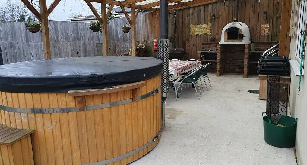 The wood fired hot tub and pizza oven canopy at New Yorker, a Harrogate hen do accommodation with sauna.