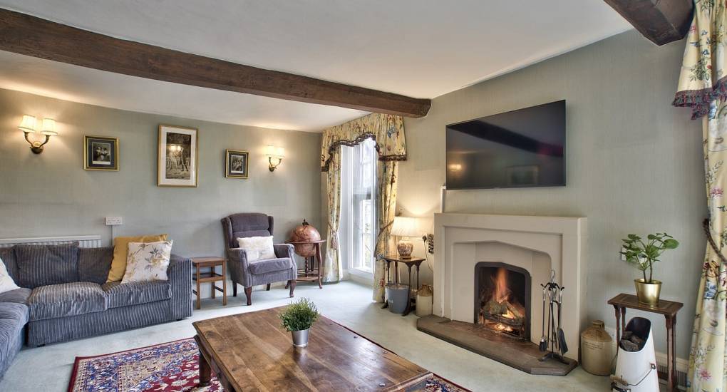 Large rug in front of lit fireplace 