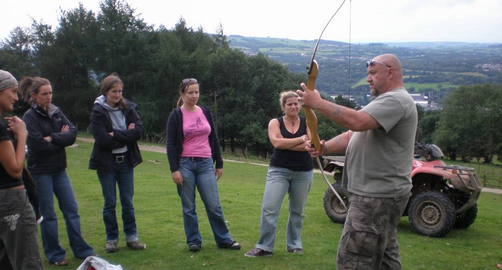 Hen do leaning about the bow before trying Archery