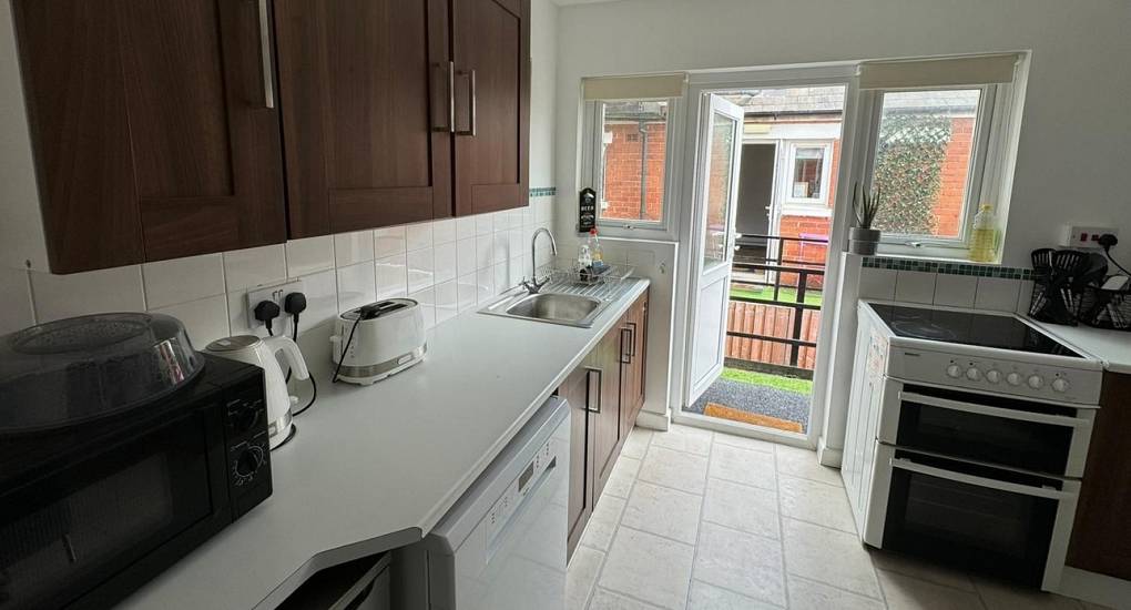 Kitchen cooker and back door open to balcony 