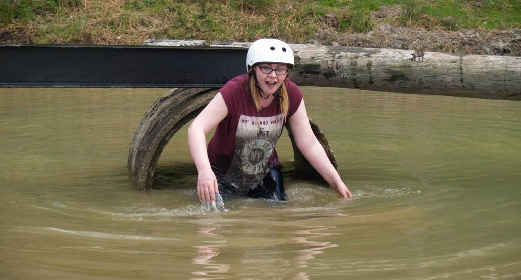 Braving the cold water. Hen taking part in the Assault Course hen party activity