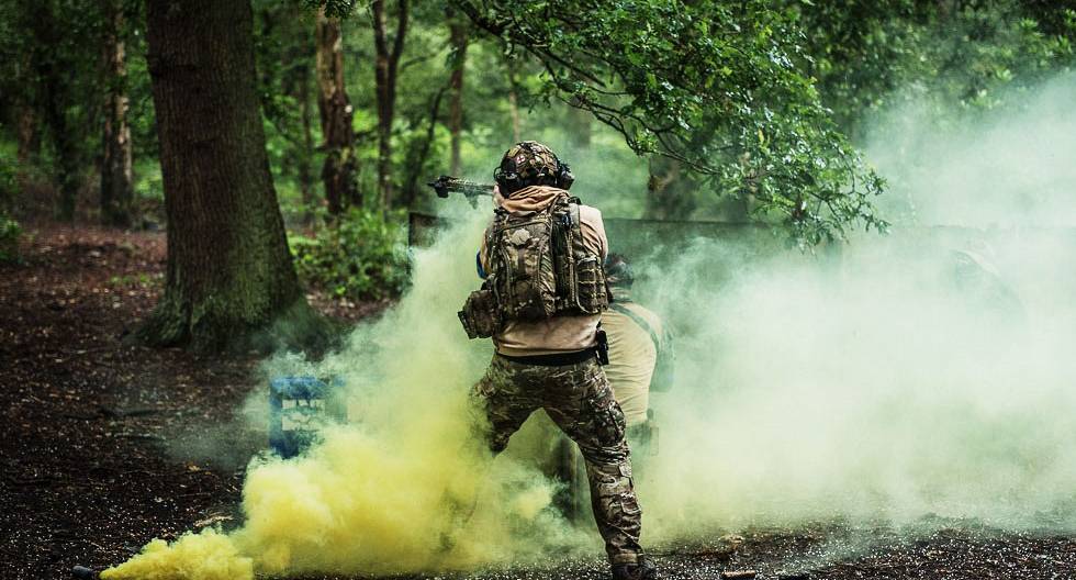 Airsoft player using smoke as cover