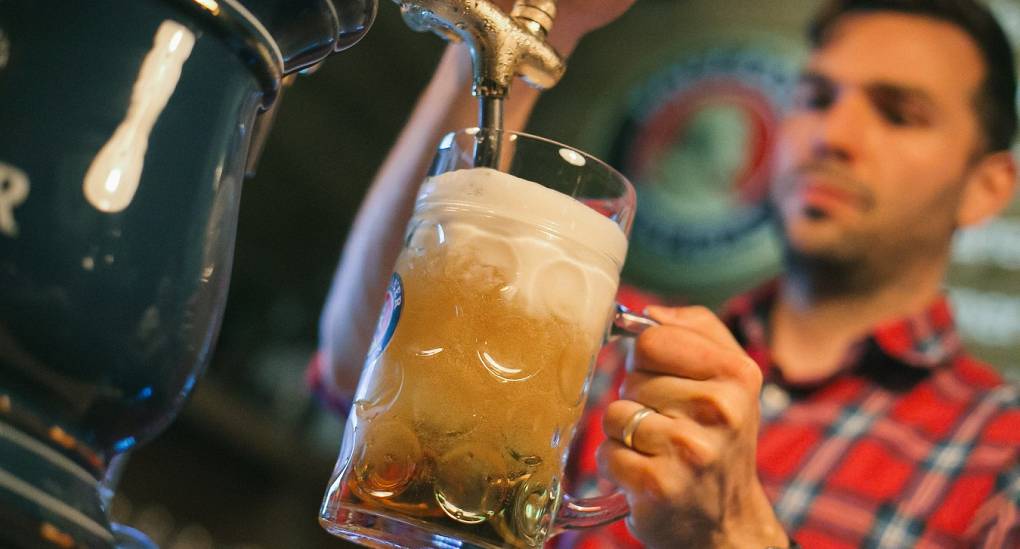 Bartender pouring a stein of traditional German Lager