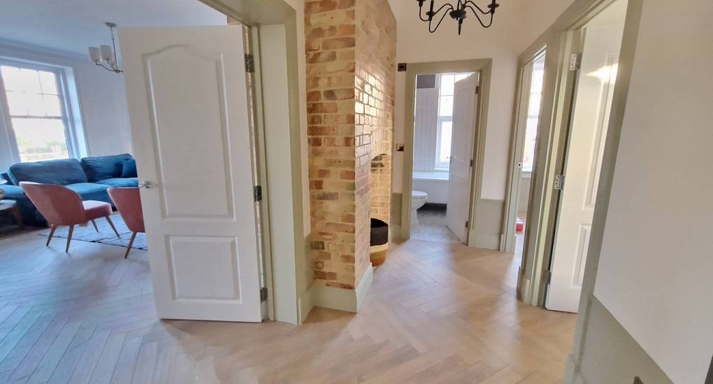 Large hallway view of bedrooms and kitchen