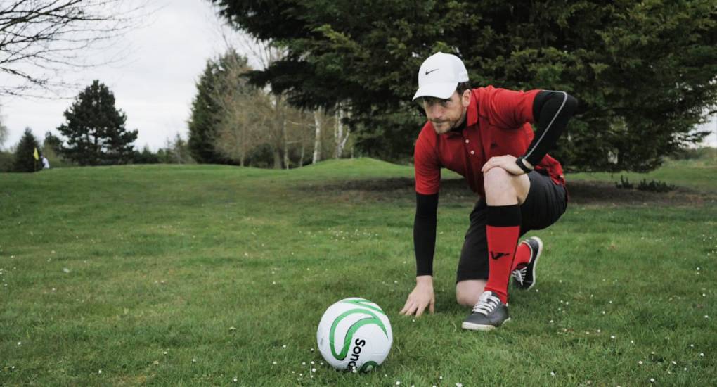 Footgolf player carefully lines up a putt playing Footgolf