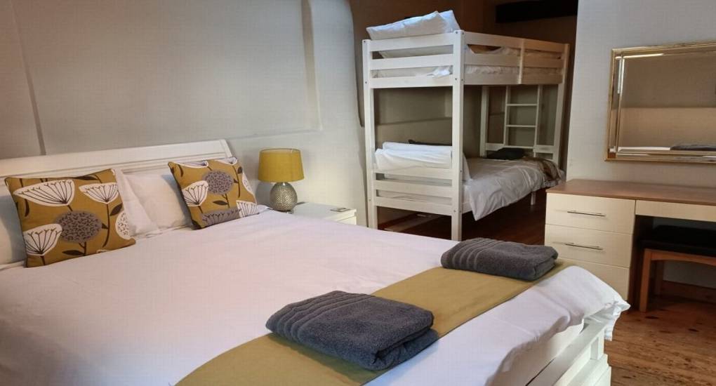 bedroom with double bed and bunk beds with vanity mirror and dressing table