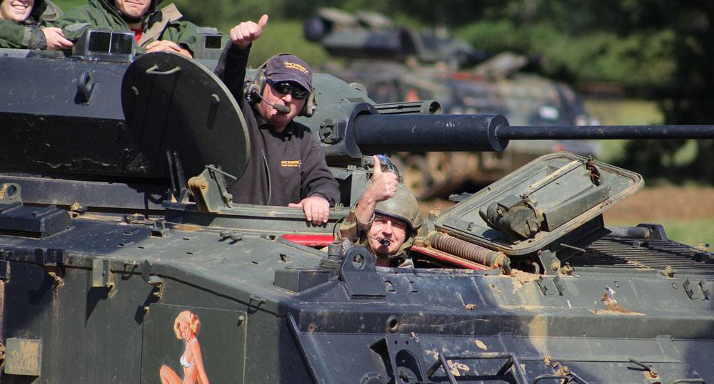 Group learning how to drive a tank