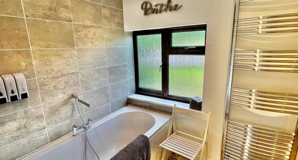 Bathroom with bath and large towel rail 