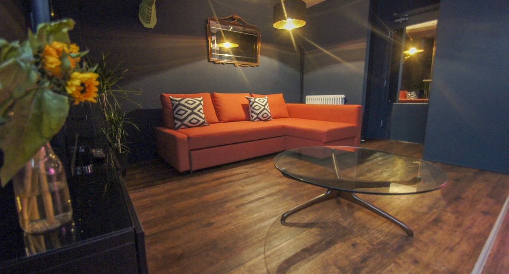 Lounge view of orange sofa and lighting 