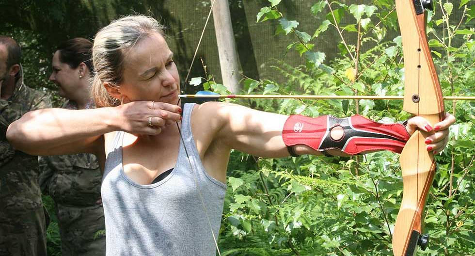 Hen taking aim whilst participating in the den do archery experience