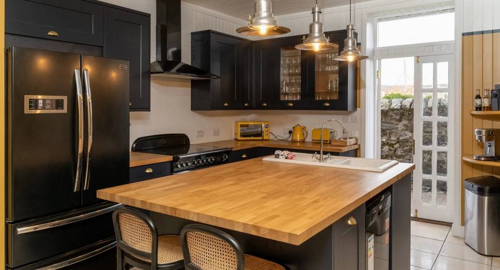 Rustic open-plan kitchen and grand dining hall at Highland House Kingussie, seating 12 guests for a Highland hen do.