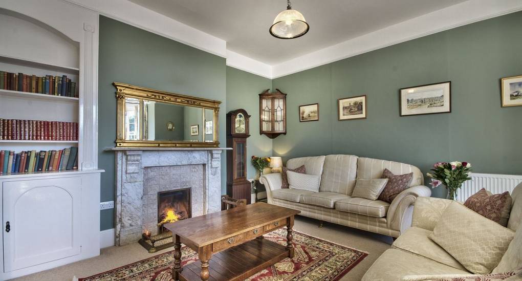 Green walled lounge with fire place 