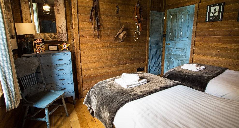 John Wayne themed bedroom with cowboy hat and whip on wall