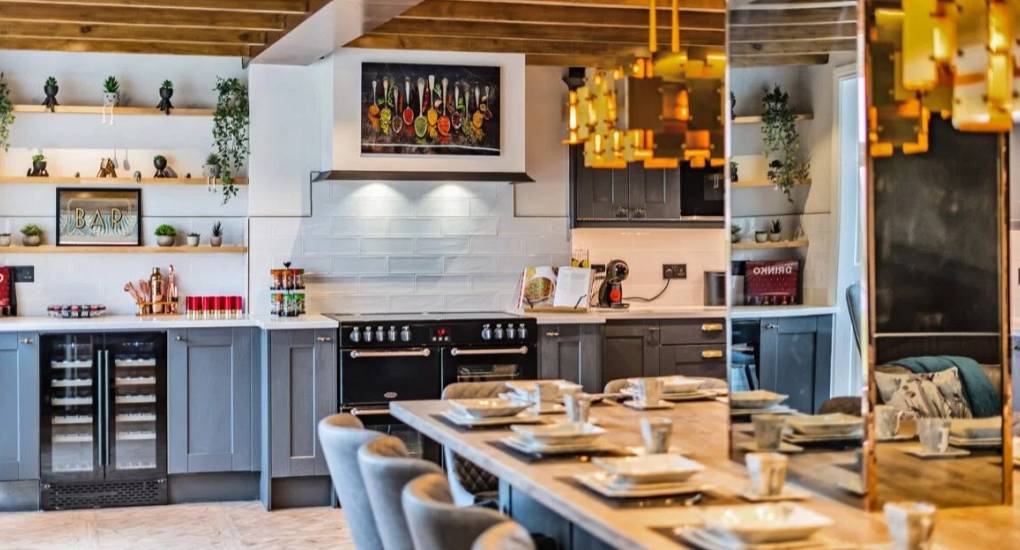 Stylish modern kitchen area viewed over the large dining table