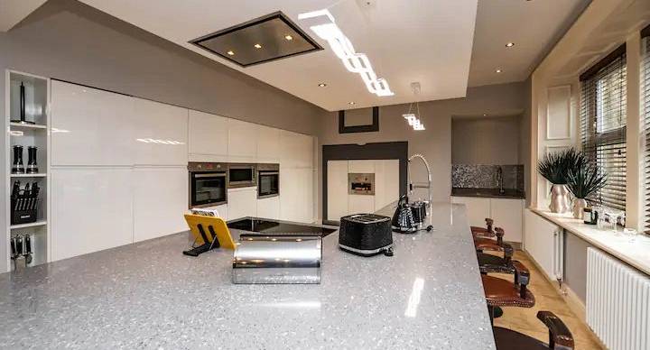 Kitchen area with white units and silver built in appliances