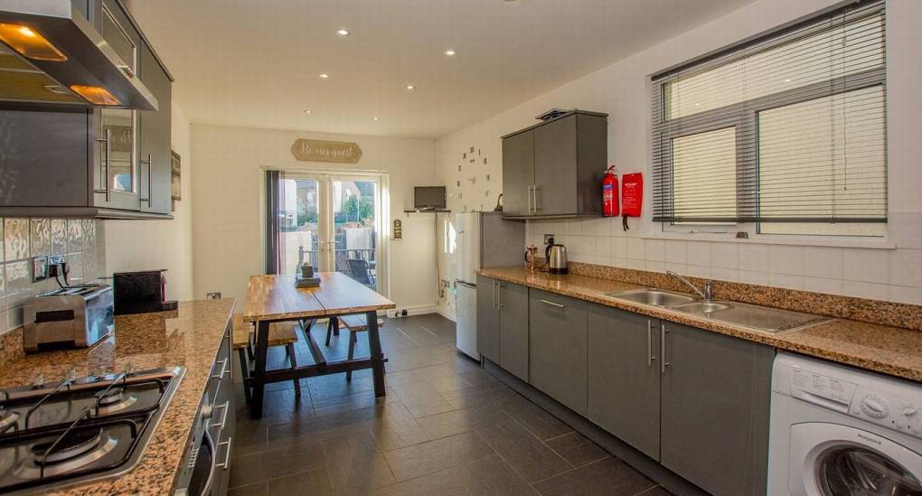 The open plan kitchen area with dining table in the background