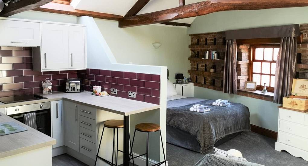 One of the kitchenettes with double bed in an open plan setting with exposed wooden beams on the ceiling