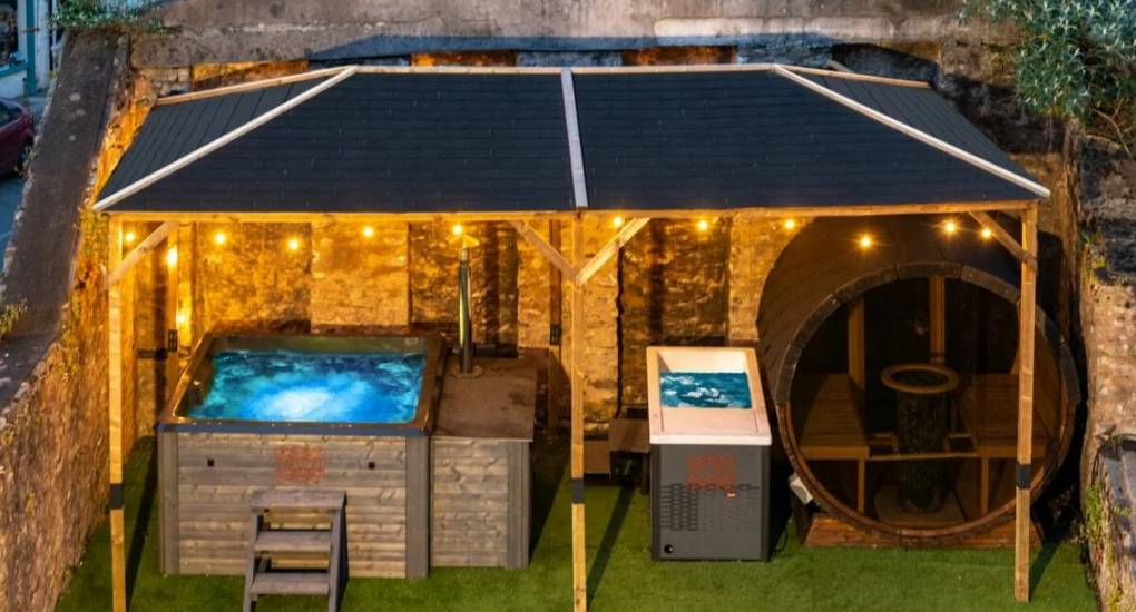 Hot tu,b, bar and seating under a dimly lit pergola