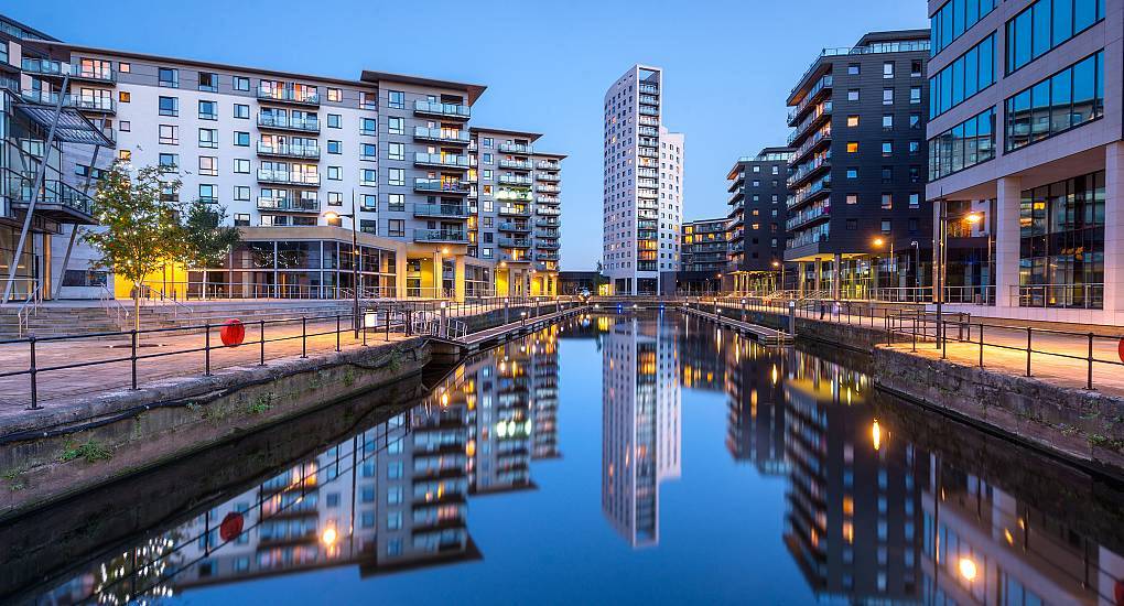 Illuminated waterfront apartments and skyline reflections at Leeds Dock, scenic setting for a Leeds hen do.