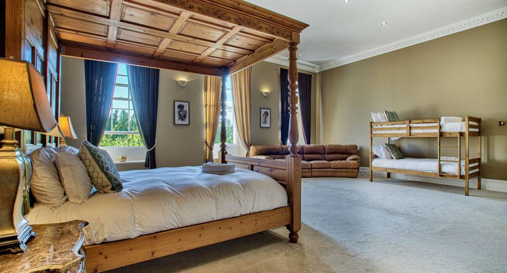 Large bedroom with 4 poster bed and bunk beds