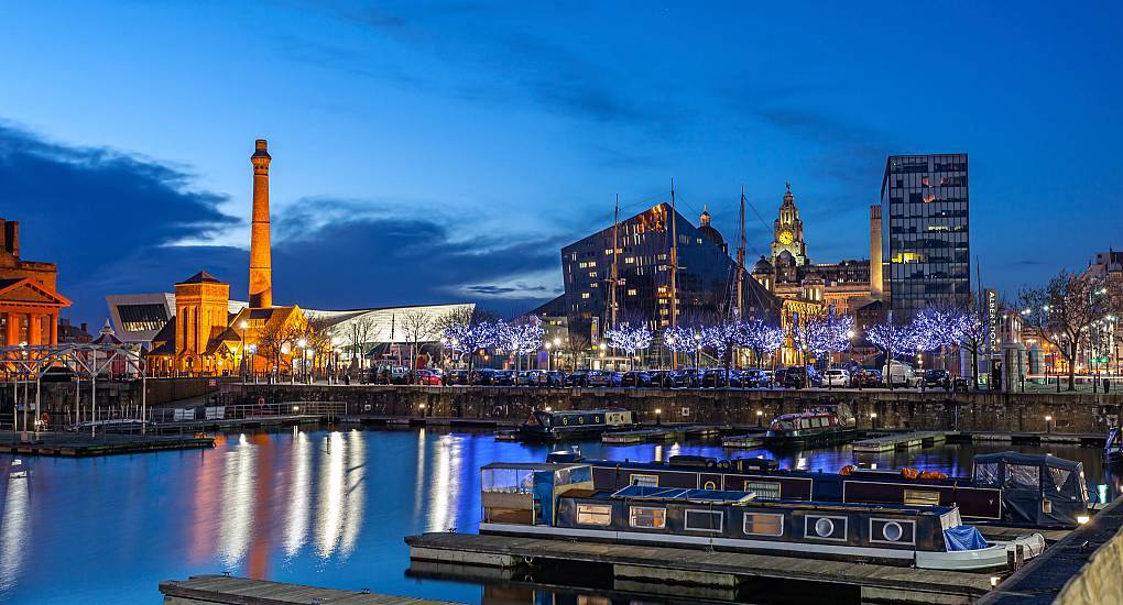 Moored canal boats and fairy-lit waterfront at Royal Albert Dock at twilight, prime location for a Liverpool stag do.