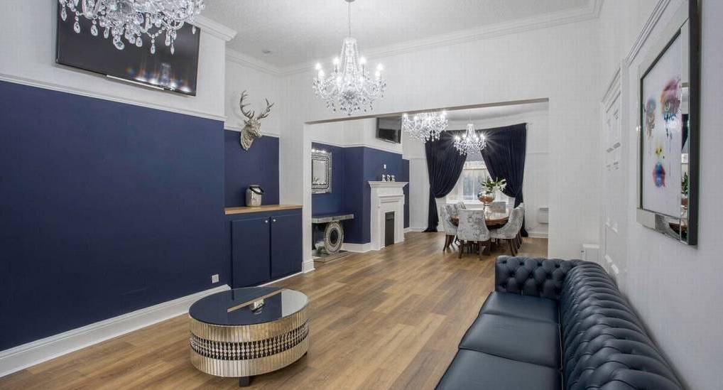 Elegant navy blue lounge with leather chesterfield sofa, crystal chandeliers and dining space at The 40 Liverpool.