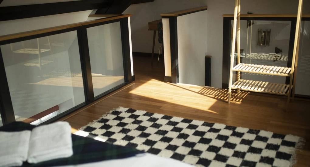 Unique mezzanine bedroom at Lux Life Edinburgh with a double bed and overlooking the living area, perfect for luxury Edinburgh city centre stag and hen groups staying in a grand townhouse.