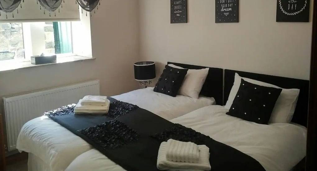 Bedroom featuring a king size bed with plum coloured throw 