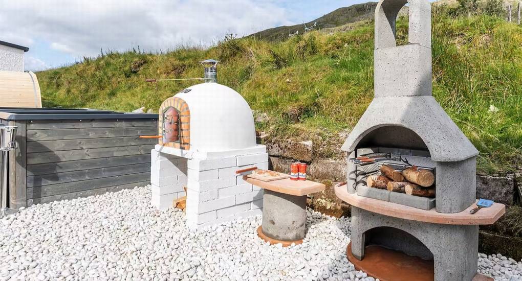 Outdoor BBQ station and fire pit area for evening socializing at the Manor on the Mountain Lake District party house