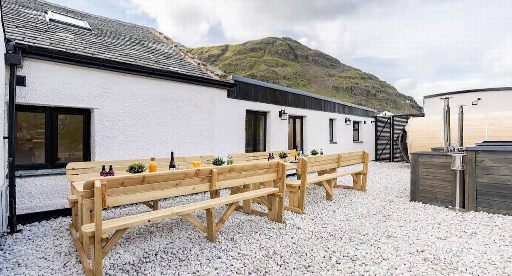 Outdoor garden area with seating and one of the two hot tubs at the Lake District luxury hen accommodation