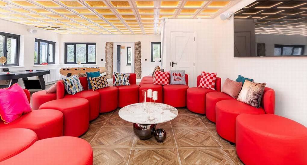 Large open-plan lounge and chill-out area featuring soft seating and easy access to the games room at the Manor on the Mountain