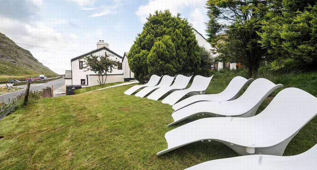 Stylish outdoor seating area with modern chairs and the Manor on the Mountain Lake District party house exterior in the background