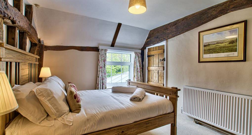 Wooden beamed double bedroom at Meadowbrook Farm Hen House