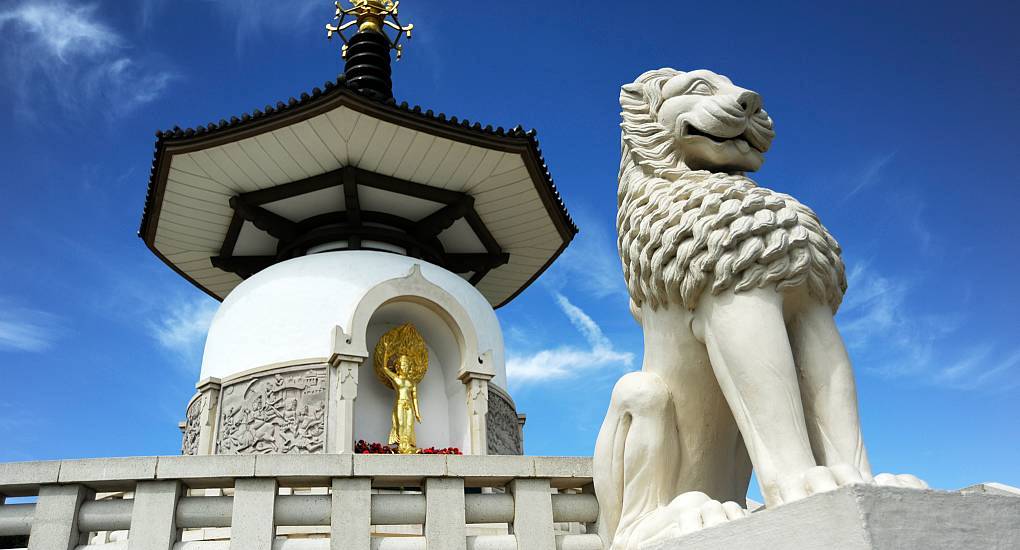 Milton Keynes Peace Pagoda dome with golden Buddha statue and stone lion at Willen Lake, ideal for a Milton Keynes stag do.