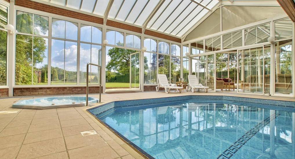 Luxury indoor heated swimming pool and jacuzzi tub in glass conservatory at The Garden Retreat near Milton Keynes.