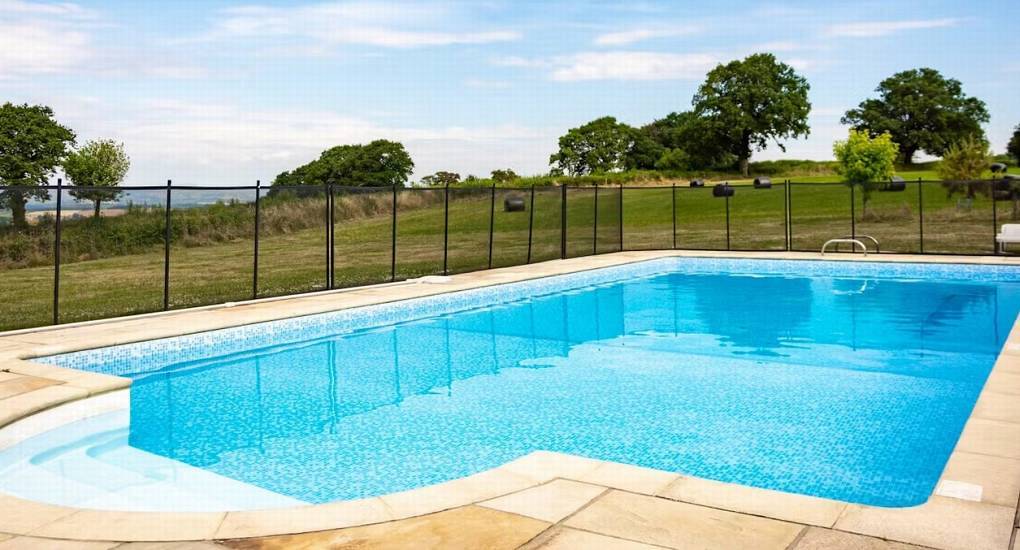 Large outdoor swimming pool with blue mosaic tile and scenic countryside views at Horizon View in Monmouthshire.