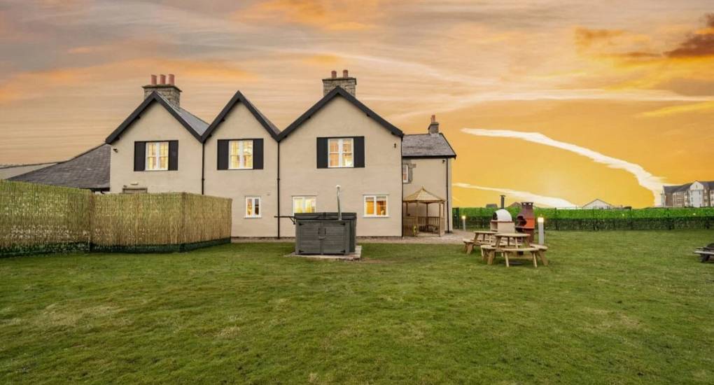 The outside of the property when viewd from the back garden at dusk with lighhting