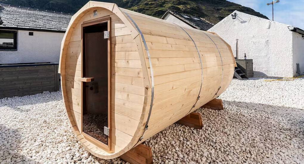 Exterior view of the wooden barrel sauna located outside Mountaintop Marvel Lake District hen do house