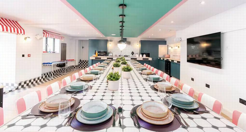 View across the long dining table showing seating capacity for large groups in the retro kitchen diner