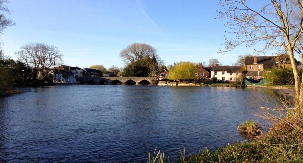 Scenic River Avon and stone arched bridge in Fordingbridge, picturesque riverside setting for a New Forest hen do.