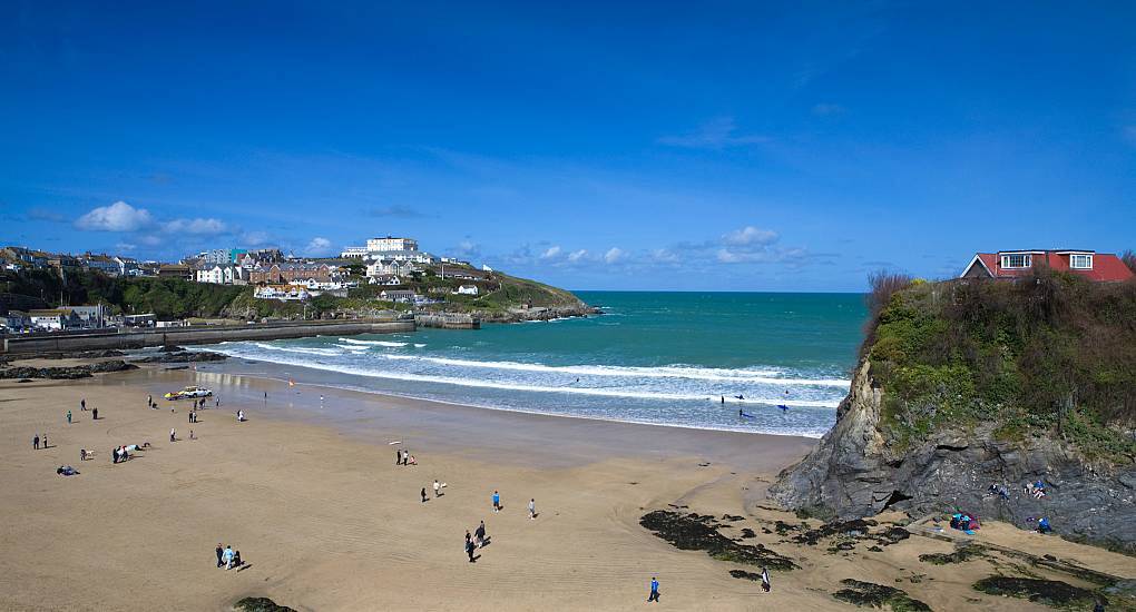 Sandy Towan Beach and rock island house in Newquay Cornwall, sunny coastal backdrop for a Newquay stag do.